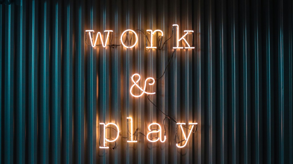 Neon sign reading work and play